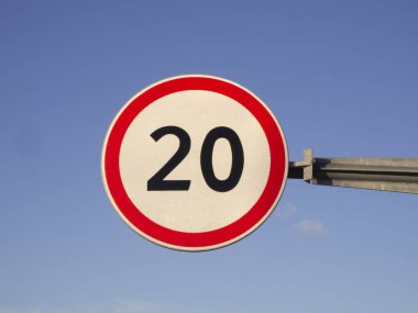 Mavi gökyüzü arka planında maksimum hız sınırı 20 km / saat yuvarlak yol işareti.
