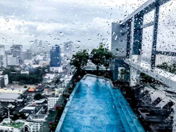 city through windows in raindrops