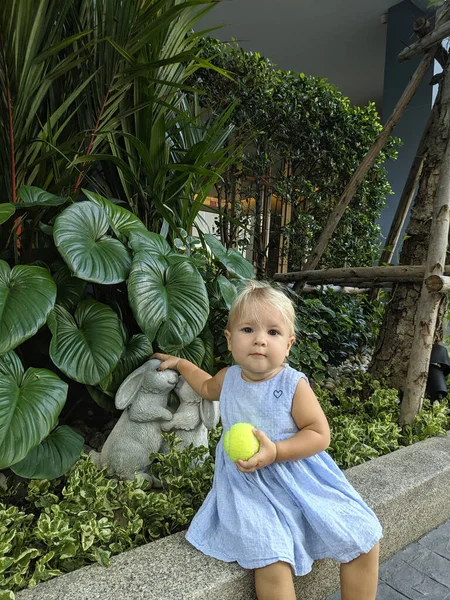 Bebé con pelota de tenis sentarse bajo el sol — Foto de Stock