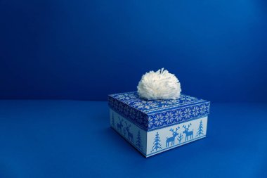 Mavi arkaplanda hediye kutusu.