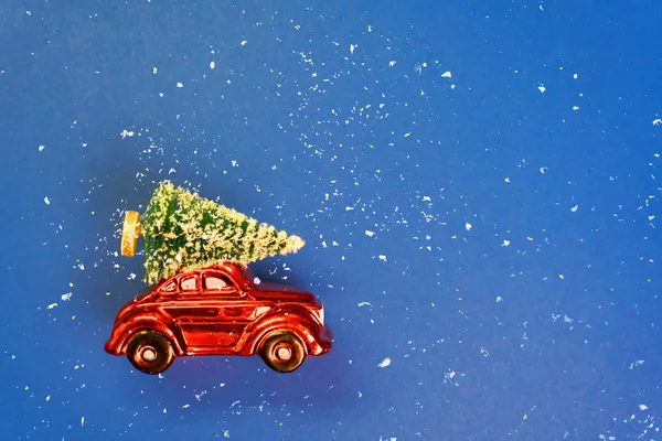 Kerstauto met boom op het dak op blauwe achtergrond — Stockfoto