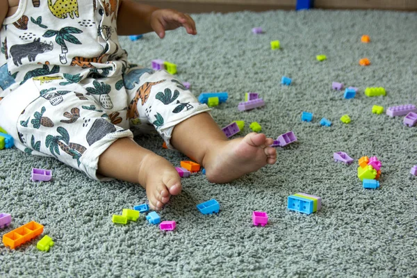 Младенец играет с игрушечными бричками — стоковое фото