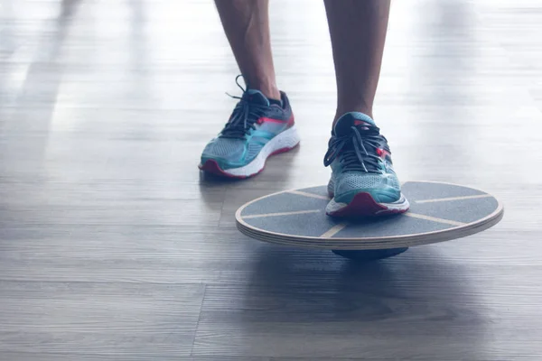 Mans benen in trainers testes balance board — Stockfoto