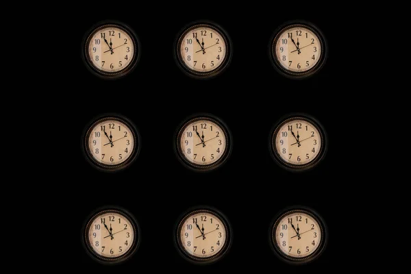 Pattern of vintage wall clocks on black background. — Stock Photo, Image