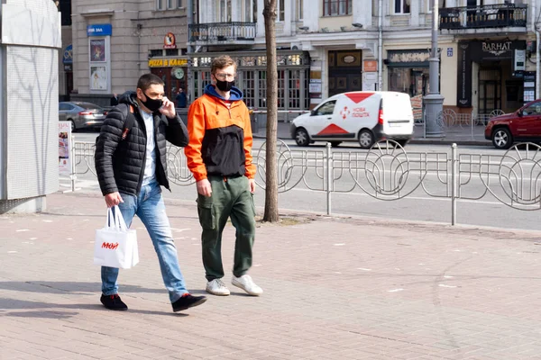 Kiev, Ukrayna, 27 Mart 2020, Yüz koruyucu maskeli iki adam sokağa gidiyor. — Stok fotoğraf