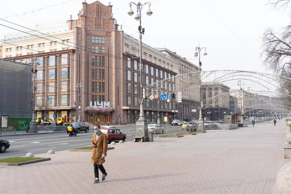 Київ, Україна, 27 березня 2020 року, людина в захисній масці на обличчі йде по вулиці — стокове фото