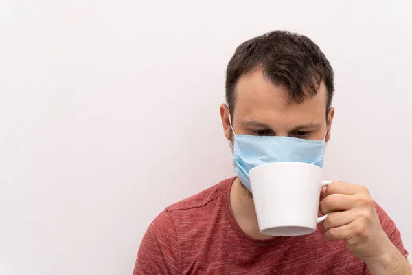 얼굴 수술용 의료용 마스크를 쓰고 있는 백인 남성 이 커피를 마시려고 한다 — 스톡 사진