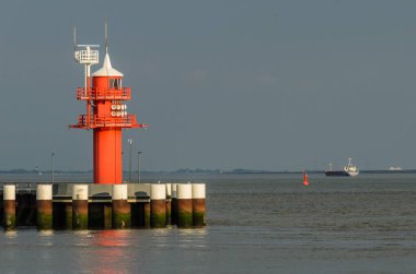 Kızıl Deniz Feneri Kiel Kanalı 'nda Kargo Gemisi Arkaplanda River Elbe' de Brunsbuettel, Almanya 'nın kuzeyinde Schleswig-Holstein