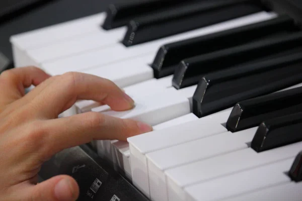 fingers of childrens hands on piano keys
