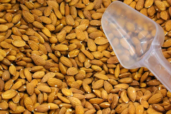 Süpermarkette bir spatulayla tepside soyulmuş badem.