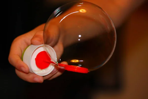 Çocuklarının elinde tuttuğu çerçevedeki sabun köpüğü.