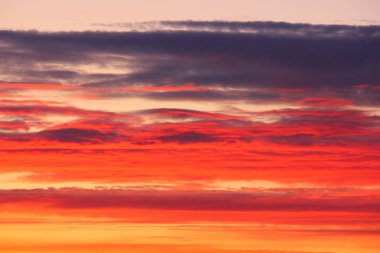 Güneş battıktan sonra gökyüzünde kırmızı-turuncu bulutlar