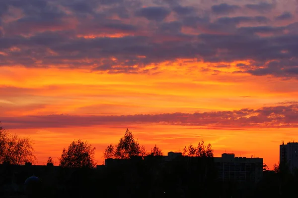 yellow-orange sunset with purple clouds over the city