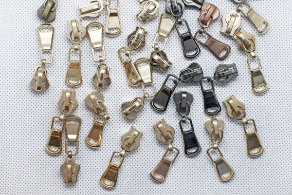 Metal zipper for clothes, bags or shoes. Fittings for making wallets of gold and black color. zipper sliders on a white background.