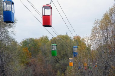 Sonbahar parkında kablolu bir araba. Çift renkli kablo kamaraları. Yolcu taşımacılığı için askıya alma yolu.