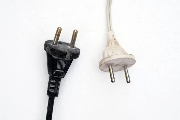 2つの電気プラグが閉じます 白の背景にワイヤと白と黒の電気プラグ コード付きの古い電気プラグ — ストック写真