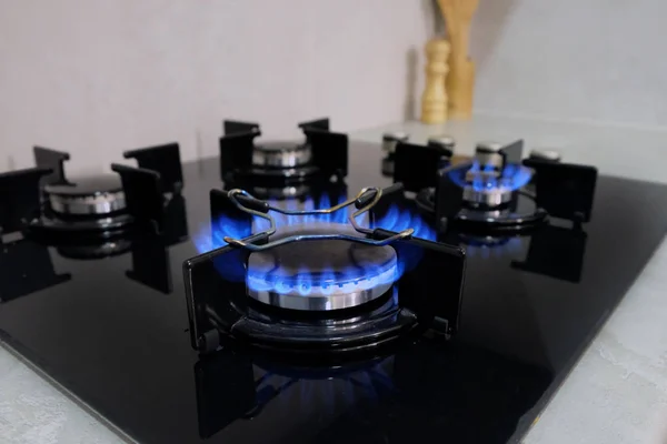 Mutfak gaz ocağında yanan gaz. Dört ocağın üzerinde sertleştirilmiş camlardan siyah bir hob. Gaz sobasından çıkan alev..