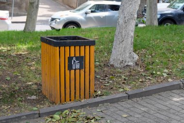 Tiflis, Gürcistan - 8 Haziran 2019: Tahta kahverengi vazo ve parkta bir tabela. Oy sandığı yeşil çimlerle kaplı, ara sokağa yakın, arabalı bir caddenin arka planında.. 