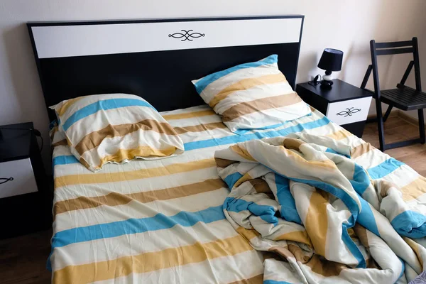 Striped sheets, pillows and duvet cover on the bed.