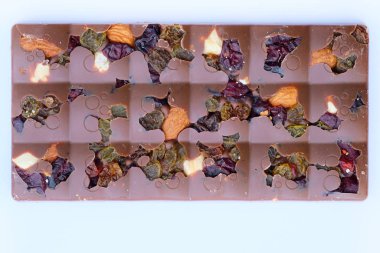 Üzümlü, kızılcıklı ve fındıklı sütlü çikolata. Bol şekerli meyveli çikolata..