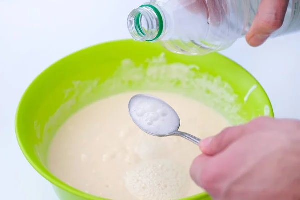 Baking soda is quenched with vinegar. A spoon of soda and a plastic bottle. The process of making dough using baking soda.