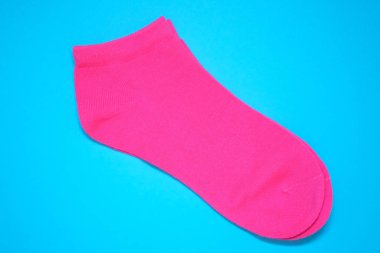 Mavi arka planda pembe çoraplar. Kadınların düşük kaliteli spor çorapları. Bir çift pamuklu çorap..