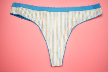Pembe arka planda çizgili tanga iç çamaşırı. Mavi elastik kadın pamuğu külodu. Kadın iç çamaşırı..