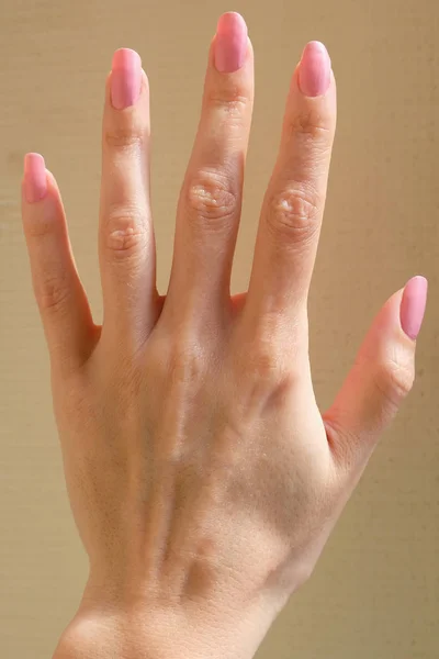Vrouwelijke Hand Een Gele Achtergrond Vingers Met Roze Lak Lange — Stockfoto