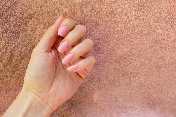 Vrouwelijke Hand Met Roze Nagellak Een Roze Achtergrond Hand Met — Stockfoto