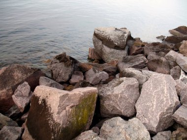 large stones on the river bank, calm water, shore, close-up
