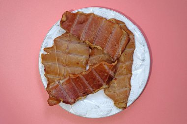 Meat snacks for beer in a white plate top view. Beer snack pork and chicken chips.