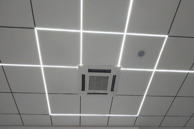 Kapalı hava kliması. LED arka ışıklandırmalı tavan versiyonu. Klima kontrol sistemi bir güzellik salonunun beyaz tavanına kurulmuştur..