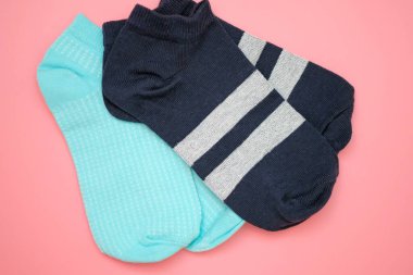 Pembe arka plan manzaralı iki çift spor çorabı. Kısa kadın çorapları mavi ve mavi renk şeritli.