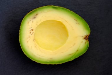 Yarım taze avokado. Siyah arkaplan görünümlü yeşil avokado.