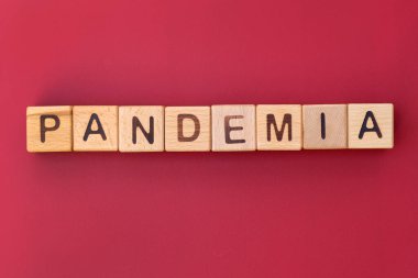 Kırmızı arkaplan görünümlü salgın kelimesi. Harfli tahta küpler. Virüsün yayılması..