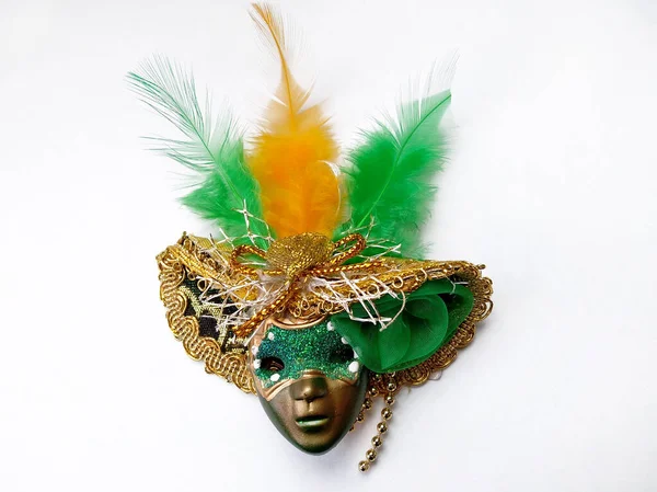 头戴塑料面具 头戴白色背景色的帽子 头戴羽毛 绿色的面具 头戴绿色和黄色羽毛的帽子 玩具娃娃的嘉年华服装 — 图库照片