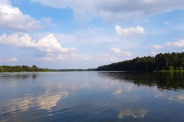 Ağaçların ve gökyüzünün yansımasıyla gölün güzel manzarası. Ukrayna 'nın batı kesimindeki bir kampanyada dinlenin..