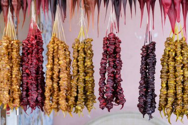 Cevizli churchkhela kırmızı, sarı ve kahverengi tezgah üzerinde bir iplik asılı. Gürcistan 'da geleneksel tatlılar. Lezzetli ve sağlıklı Gürcü tatlılar.