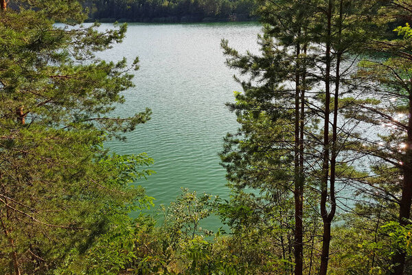 view of the lake through the trees, a beautiful view of the blue lake in the Chernihiv region, Ukraine.