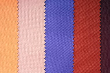 Pastel tonlarda kumaş örnekleri. Mavi, kırmızı, sarı kumaş parçası. Özel bir kaplaması olan belli bir yapının sentetik liflerinden (naylon veya polyester) yapılmış hafif kumaşı.