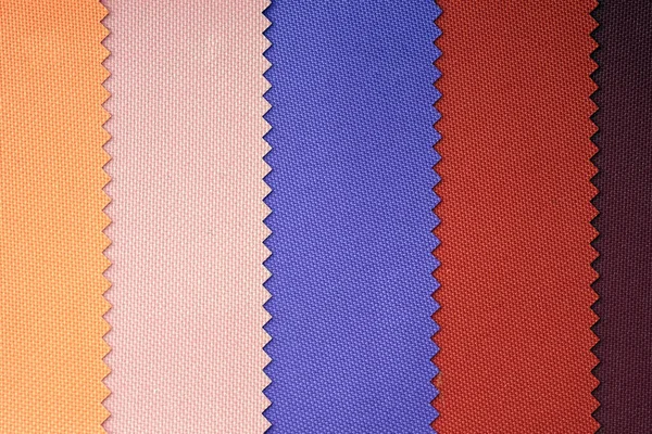 Samples of fabrics in pastel shades. Blue, red, yellow piece of fabric with texture. Lightweight fabric made of synthetic fibres (nylon or polyester) of a certain structure with a special coating.