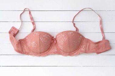 Pembe dantelli sütyen. Beyaz ahşap arka planda destekli sütyen. Klasik seksi iç çamaşırı işte. Güzel, tam kaplamalı sutyen. İç çamaşırı mağazası konsepti, satış, özel teklif