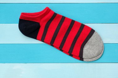 Kırmızı pamuklu çorapların üst manzarası. Ahşap mavi arka planda kısa parlak çoraplar. Spor, spor ve yoga için bir çift çorap..