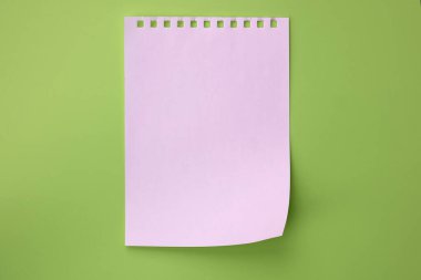 Açık yeşil arka planda beyaz yırtık defter sayfası, üst manzara. Düz renkli bir arkaplanda bir kağıt parçası boş. Uzayı kopyala Not planları için beyaz kağıt sayfa, yapışkan notlar.