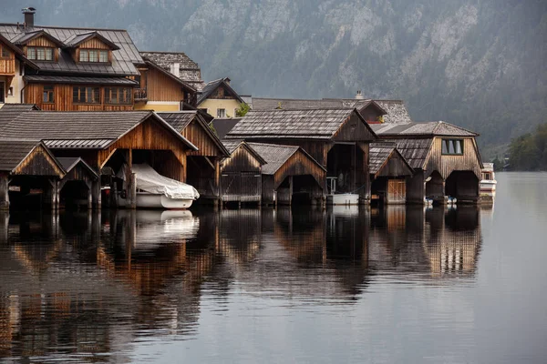 Fila de antiguos cobertizos barco de madera en el agua en el lago temprano en la mañana. Halstatt Austria Imágenes De Stock Sin Royalties Gratis