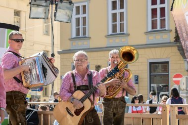 Graz / Avusturya - Eylül 2019: geleneksel Styrian halk kültürü (Aufsteirern) sonbahar festivali. Parlak geleneksel elbiseli bir grup adam şehir meydanında halk müziği çalıyorlar..