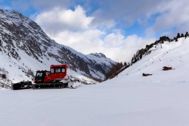 Ischgl, Avusturya - Ocak 2020: Dağların arkasındaki Avusturya Alplerinde kayak hazırlıkları için kullanılan kırmızı makine.