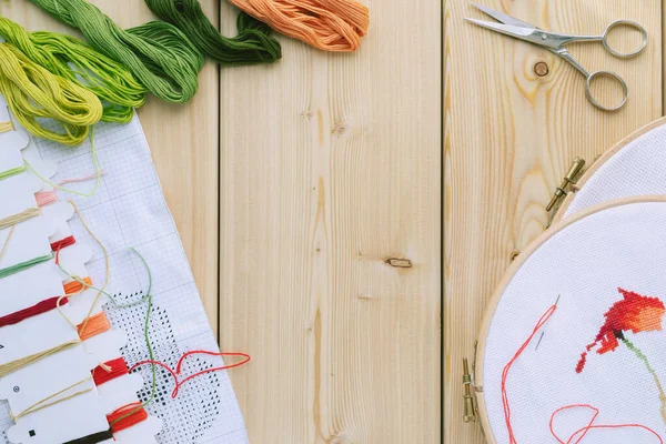 Embroidery hoop and multicolored accessories on white linen canvas with  spools of thread, needle and scissors Stock Photo - Alamy