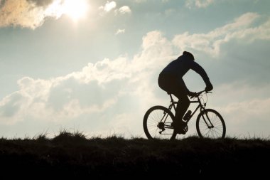 Bisikletçi bulutlu gökyüzü karşı