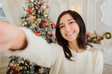 Kız cep telefonuyla noel fotoğrafı çekiyor.